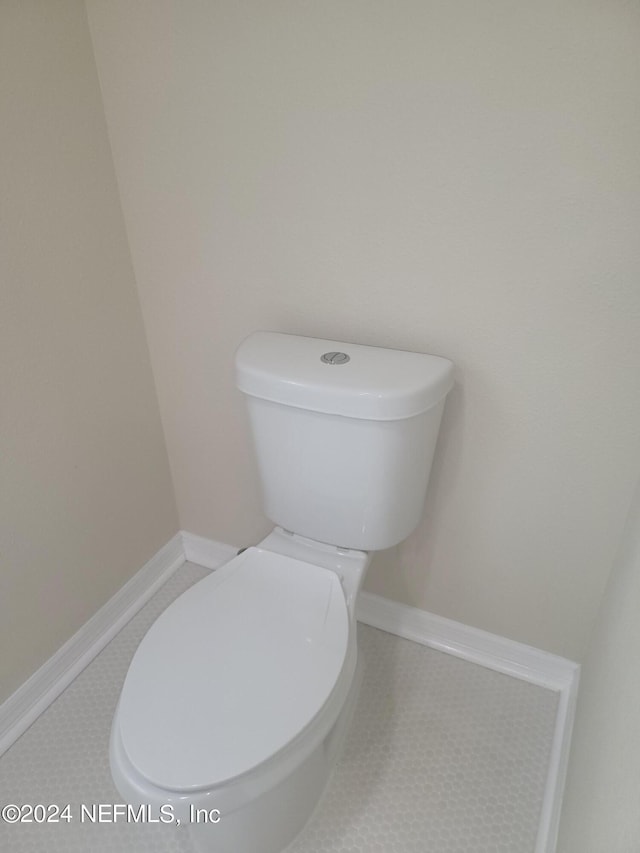 bathroom with toilet and tile patterned flooring