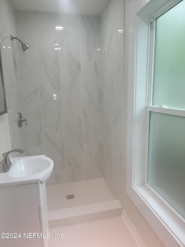 bathroom with vanity and a tile shower