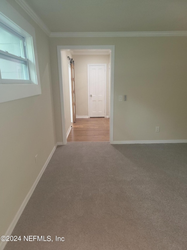 carpeted empty room with baseboards and crown molding