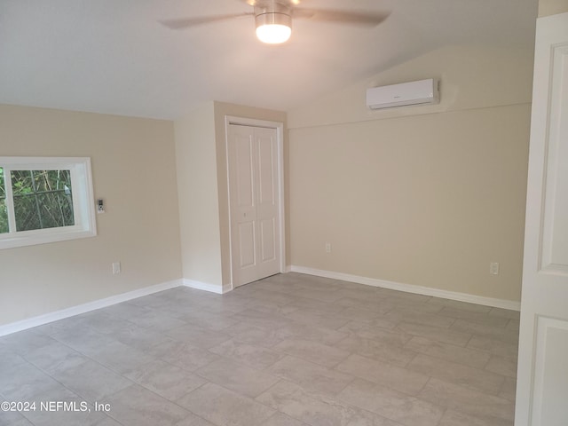 unfurnished bedroom with lofted ceiling, a ceiling fan, baseboards, a wall mounted AC, and a closet