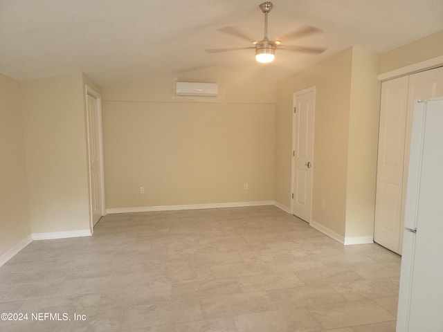 unfurnished room with vaulted ceiling, an AC wall unit, a ceiling fan, and baseboards