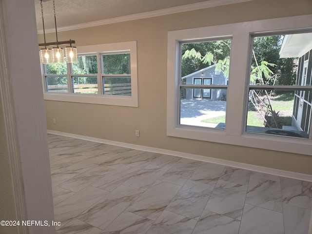 spare room featuring ornamental molding, marble finish floor, plenty of natural light, and baseboards