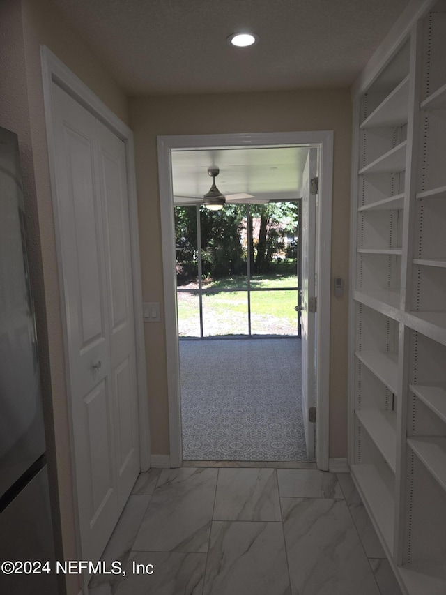 doorway with marble finish floor, baseboards, and recessed lighting