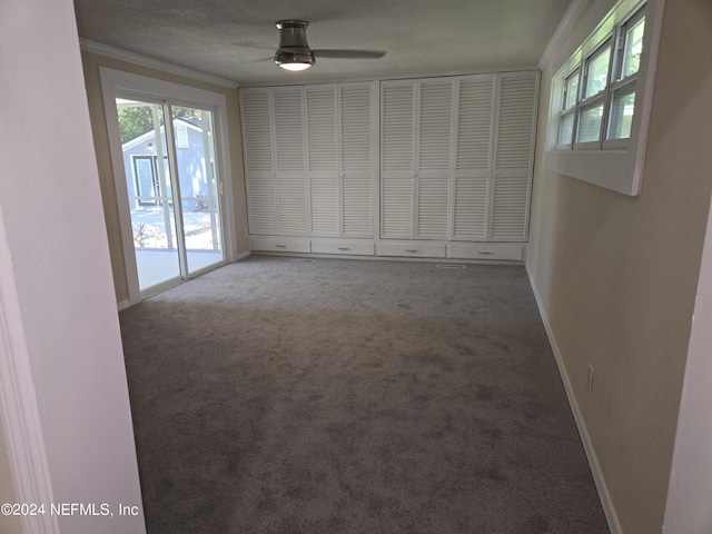 spare room featuring baseboards, carpet, ornamental molding, and a wealth of natural light