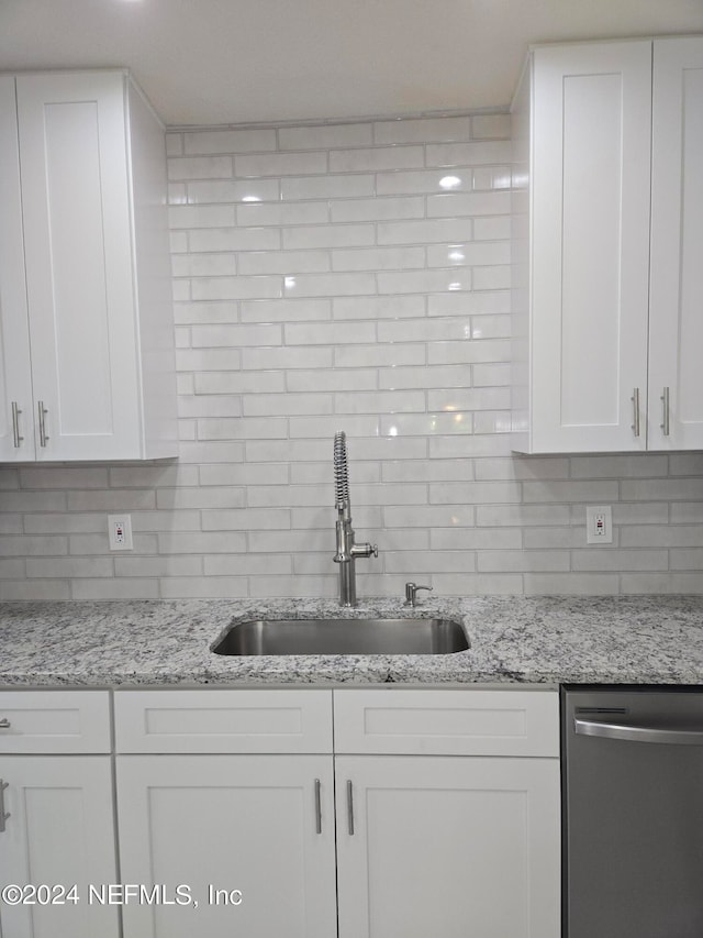 kitchen with white cabinetry, sink, and stainless steel dishwasher