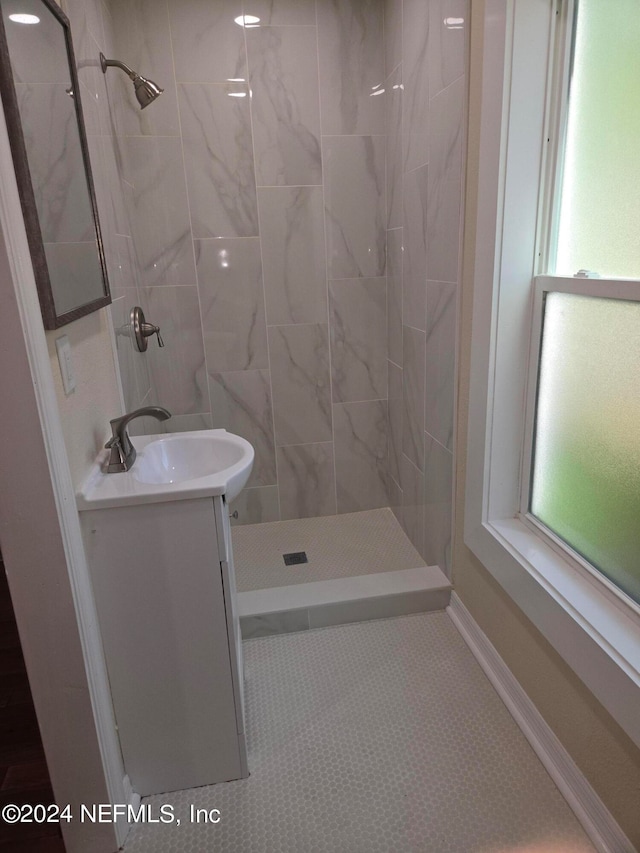 bathroom with vanity and a tile shower