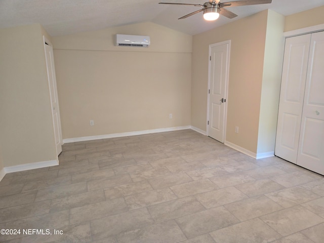 unfurnished bedroom featuring lofted ceiling and a wall unit AC