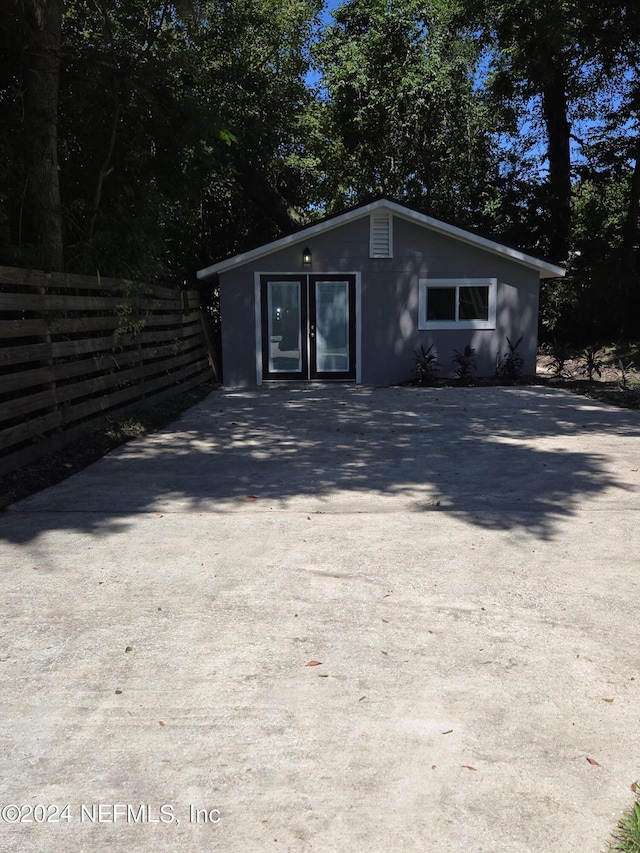 view of outbuilding featuring fence and driveway