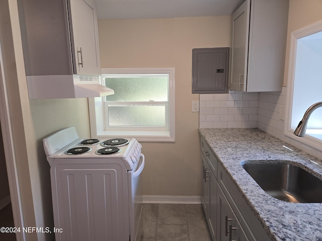 kitchen with tasteful backsplash, electric panel, white electric stove, light stone countertops, and a sink