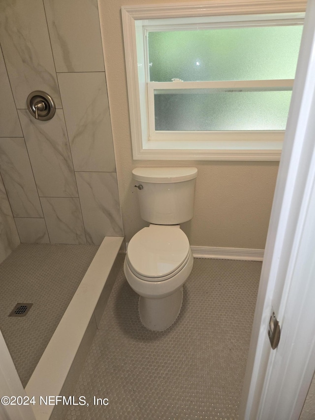 full bath featuring tile patterned floors, a shower stall, toilet, and baseboards