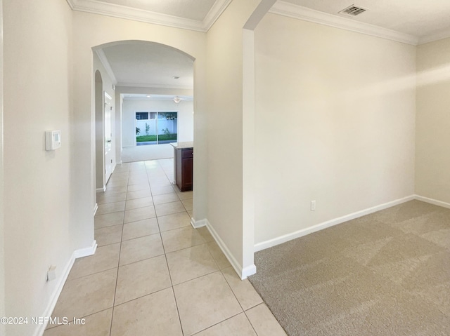 hall featuring light tile patterned floors and ornamental molding