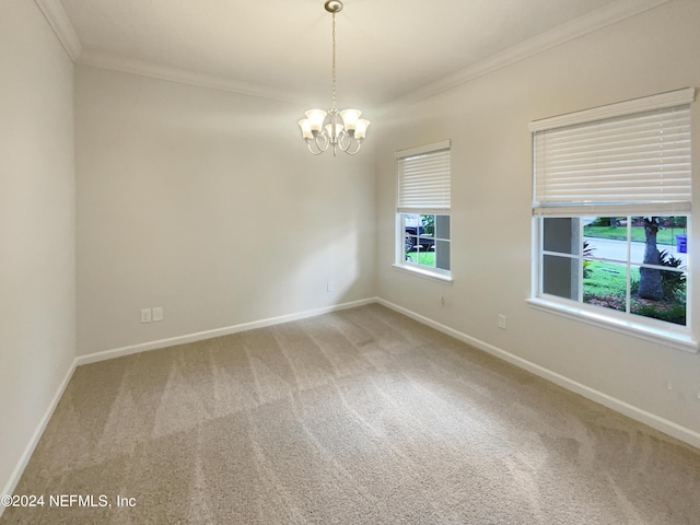 carpeted empty room featuring ornamental molding and an inviting chandelier