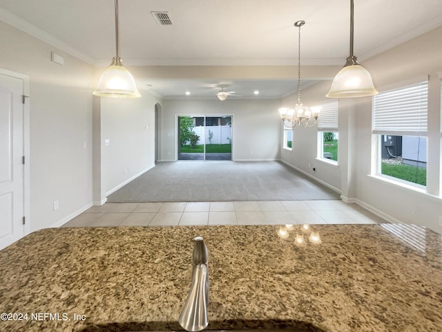 kitchen featuring crown molding, light tile patterned floors, pendant lighting, and ceiling fan with notable chandelier