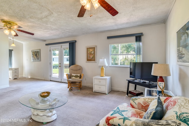 living room with carpet floors, a textured ceiling, ceiling fan, and a healthy amount of sunlight