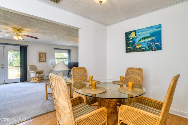 carpeted dining room featuring a textured ceiling and ceiling fan