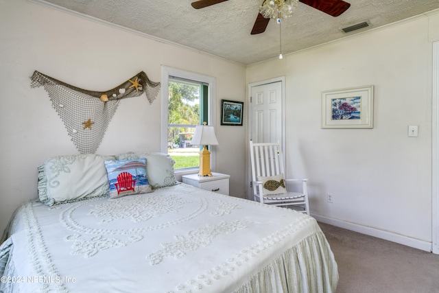 bedroom with a textured ceiling, carpet, and ceiling fan