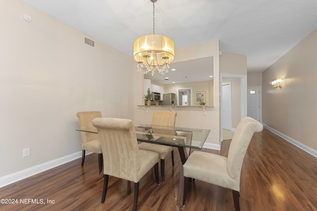 dining space with a notable chandelier and dark hardwood / wood-style flooring