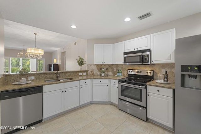 kitchen featuring sink, a notable chandelier, decorative backsplash, white cabinets, and appliances with stainless steel finishes