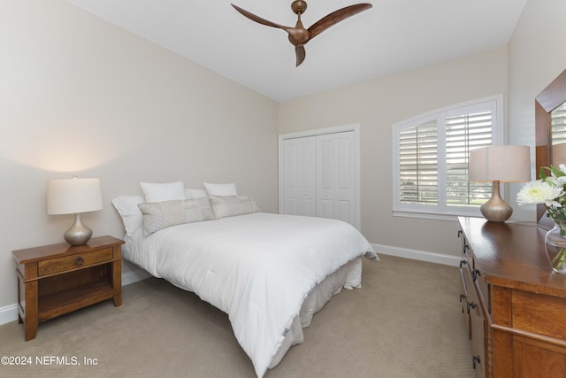 carpeted bedroom featuring ceiling fan and a closet