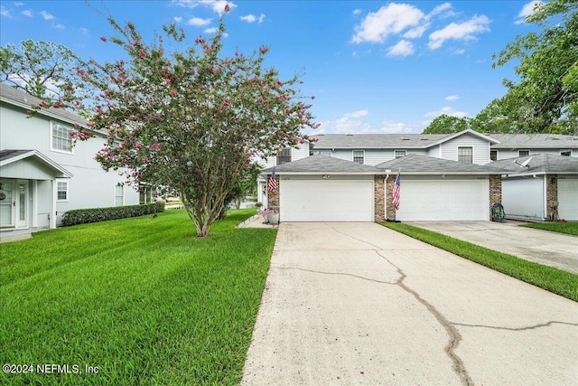 front facade with a garage and a front lawn