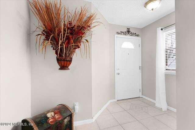 tiled foyer with a textured ceiling