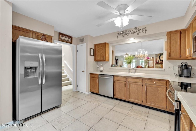 kitchen with stainless steel appliances, sink, light tile patterned floors, and ceiling fan