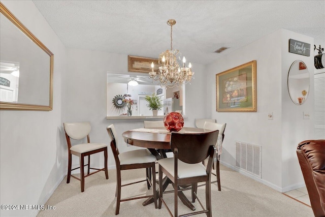 dining space with light colored carpet, ceiling fan with notable chandelier, and a textured ceiling