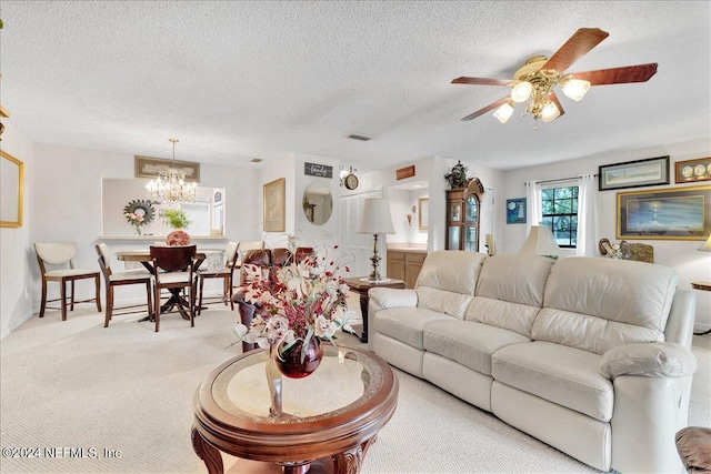 carpeted living room featuring ceiling fan with notable chandelier and a textured ceiling