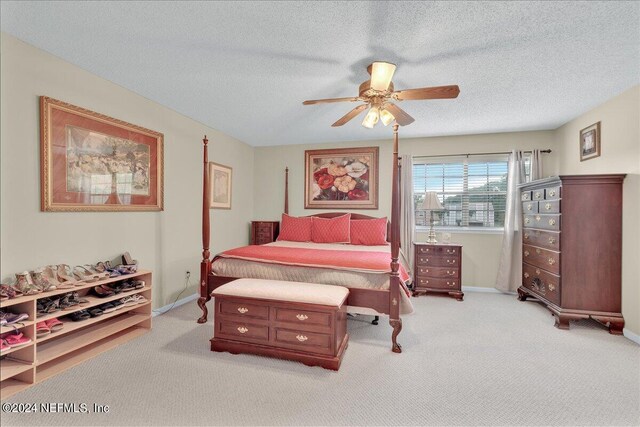 carpeted bedroom with a textured ceiling and ceiling fan