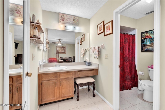 bathroom with toilet, a textured ceiling, vanity, ceiling fan, and tile patterned flooring