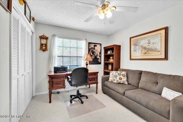 office area with ceiling fan, light colored carpet, and a textured ceiling