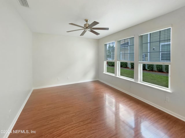 empty room with ceiling fan and hardwood / wood-style floors