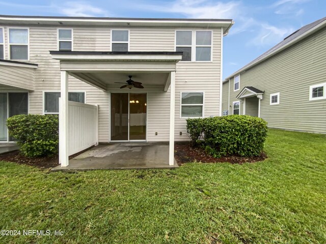 back of property with a yard, ceiling fan, and a patio area