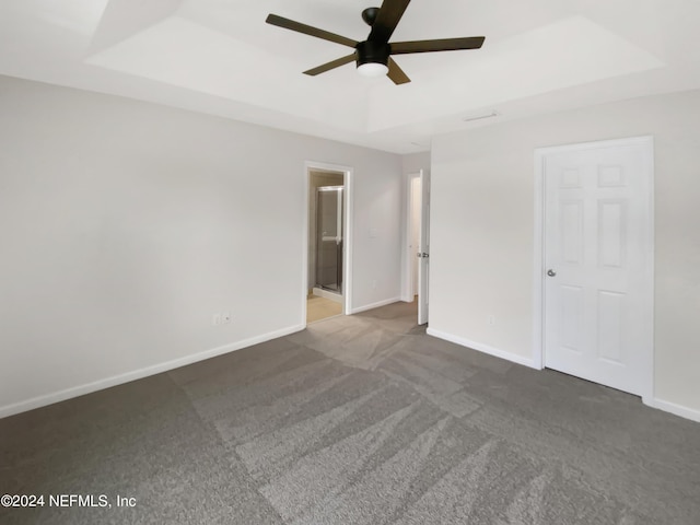 interior space with a raised ceiling and ceiling fan