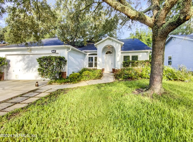 ranch-style house with a garage and a front lawn