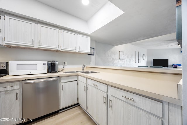 kitchen with ceiling fan, sink, stainless steel dishwasher, and light wood-type flooring