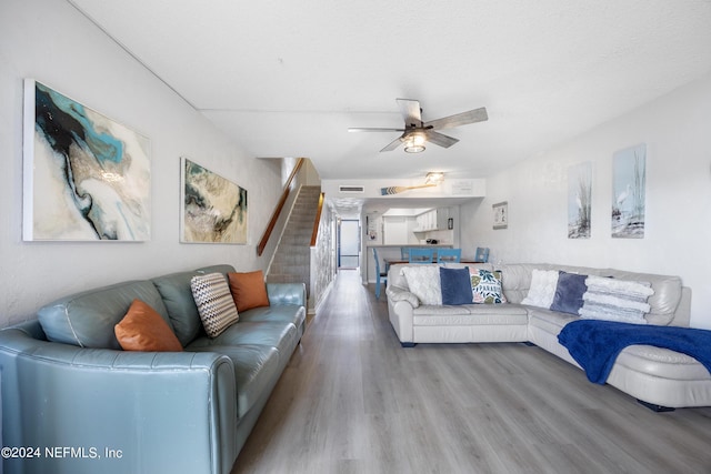 living room featuring hardwood / wood-style floors and ceiling fan