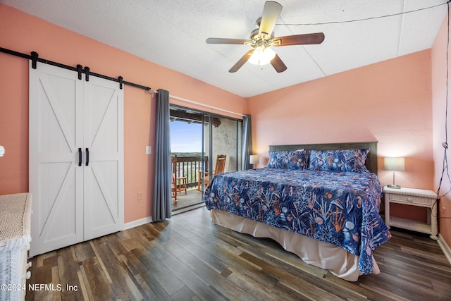 bedroom featuring a textured ceiling, access to outside, ceiling fan, dark wood-type flooring, and a barn door