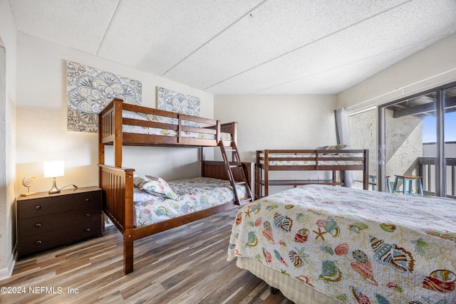 bedroom with access to exterior and wood-type flooring