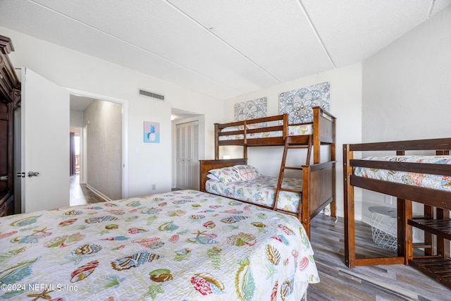 bedroom featuring hardwood / wood-style floors, a textured ceiling, and a closet