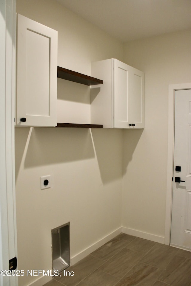 laundry area with baseboards, hookup for an electric dryer, and cabinet space