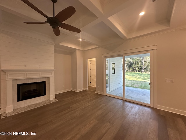 unfurnished living room with coffered ceiling, ceiling fan, dark wood-type flooring, beam ceiling, and a fireplace