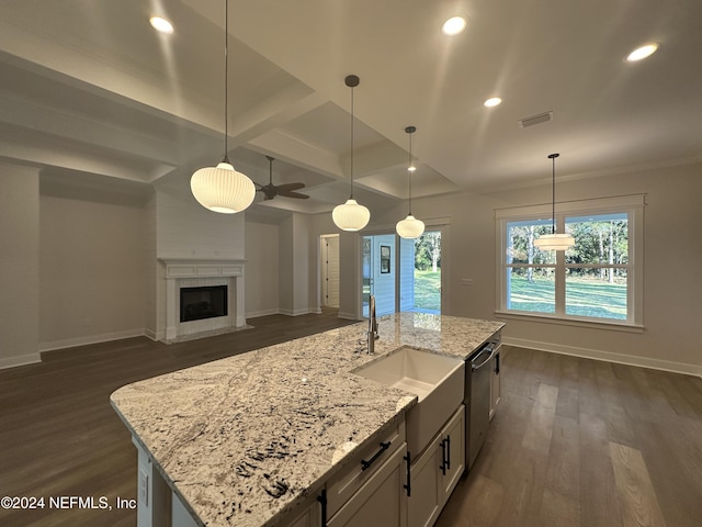 kitchen with ceiling fan, dark wood-type flooring, coffered ceiling, light stone counters, and decorative light fixtures