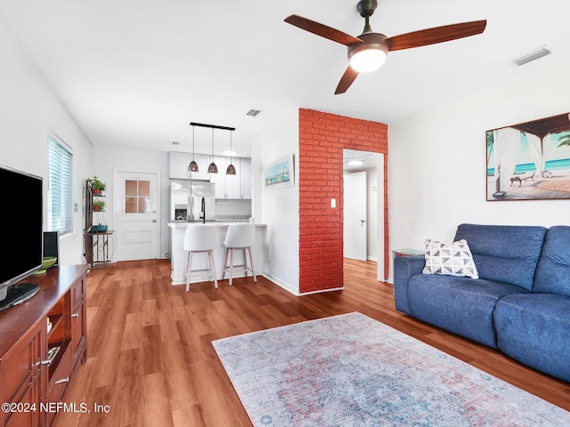 living room featuring light wood-type flooring and ceiling fan