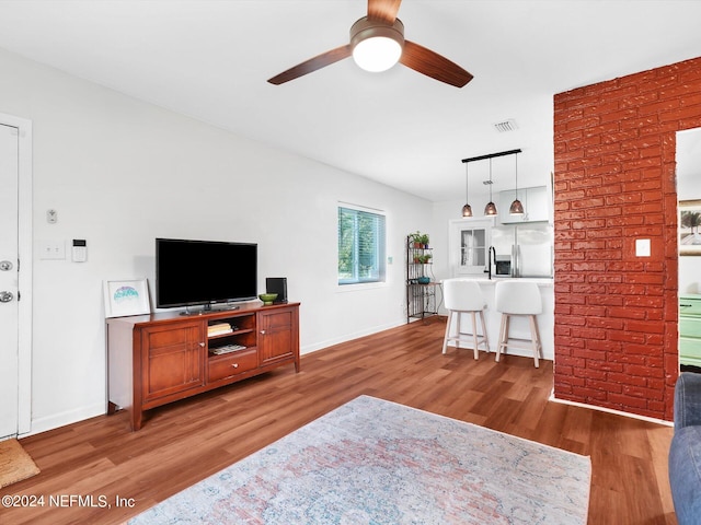 living room featuring ceiling fan and hardwood / wood-style flooring