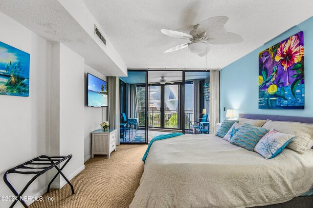 bedroom featuring ceiling fan, carpet flooring, access to outside, a wall of windows, and a textured ceiling