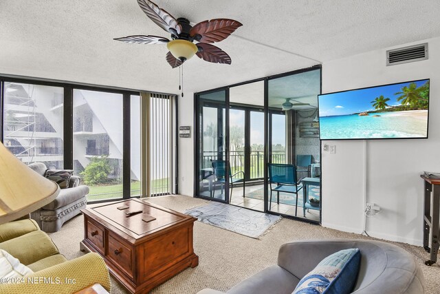 carpeted living room with expansive windows, a textured ceiling, and ceiling fan