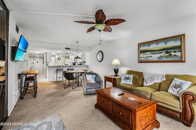 carpeted living room featuring a textured ceiling and ceiling fan