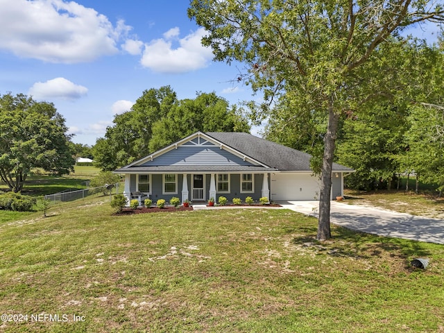 view of front of house featuring a porch, a garage, and a front yard