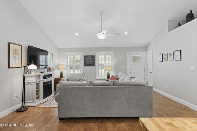 living room with hardwood / wood-style flooring, vaulted ceiling, and ceiling fan